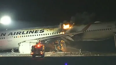 japan airlines plane with 367 onboard catches fire on runway at tokyo airport